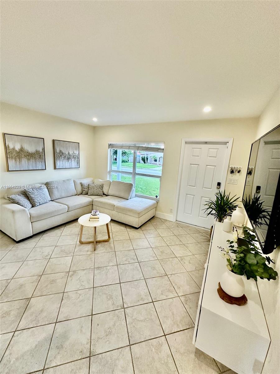 a living room with furniture and a potted plant