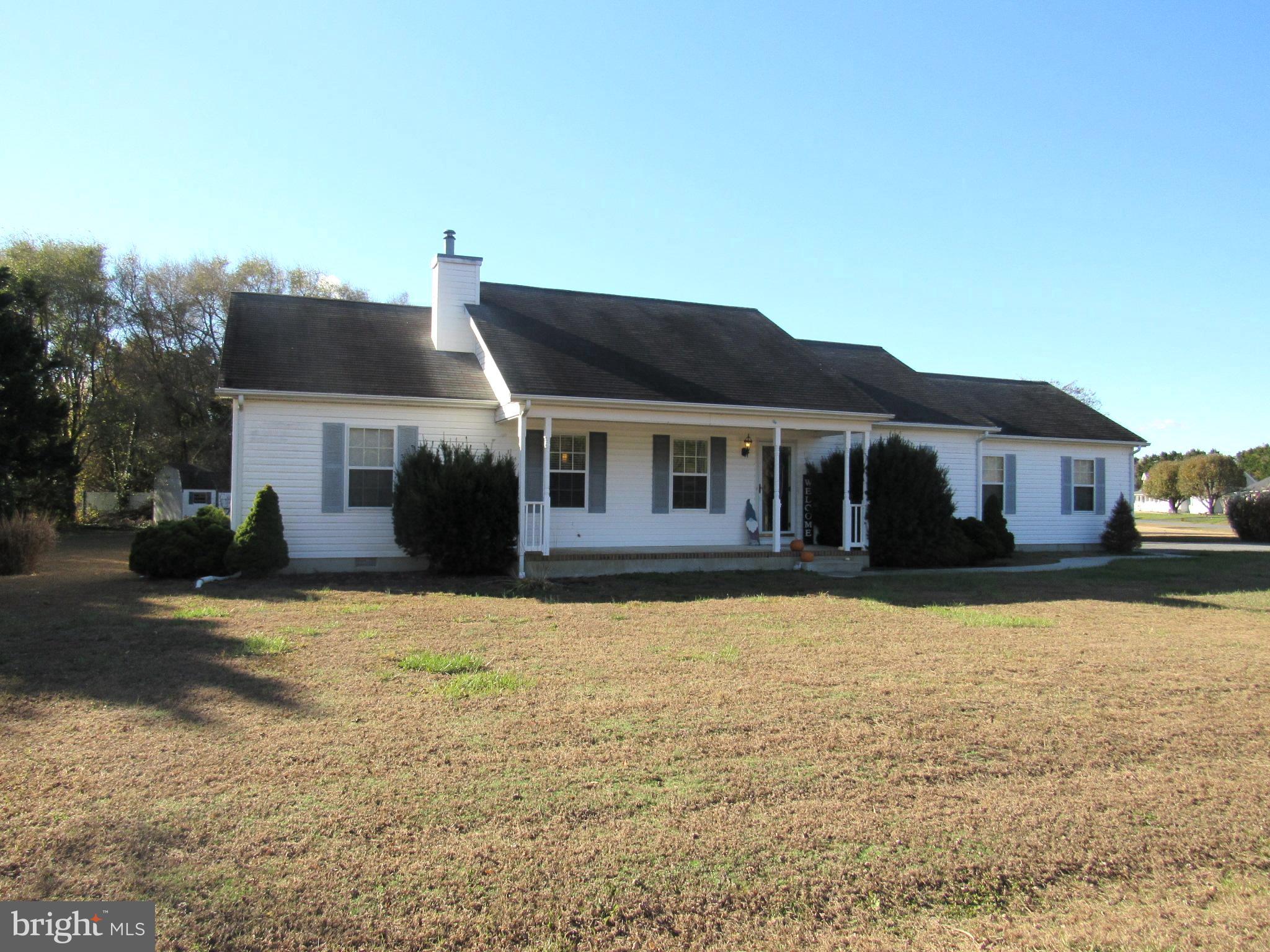 a front view of a house with yard and road