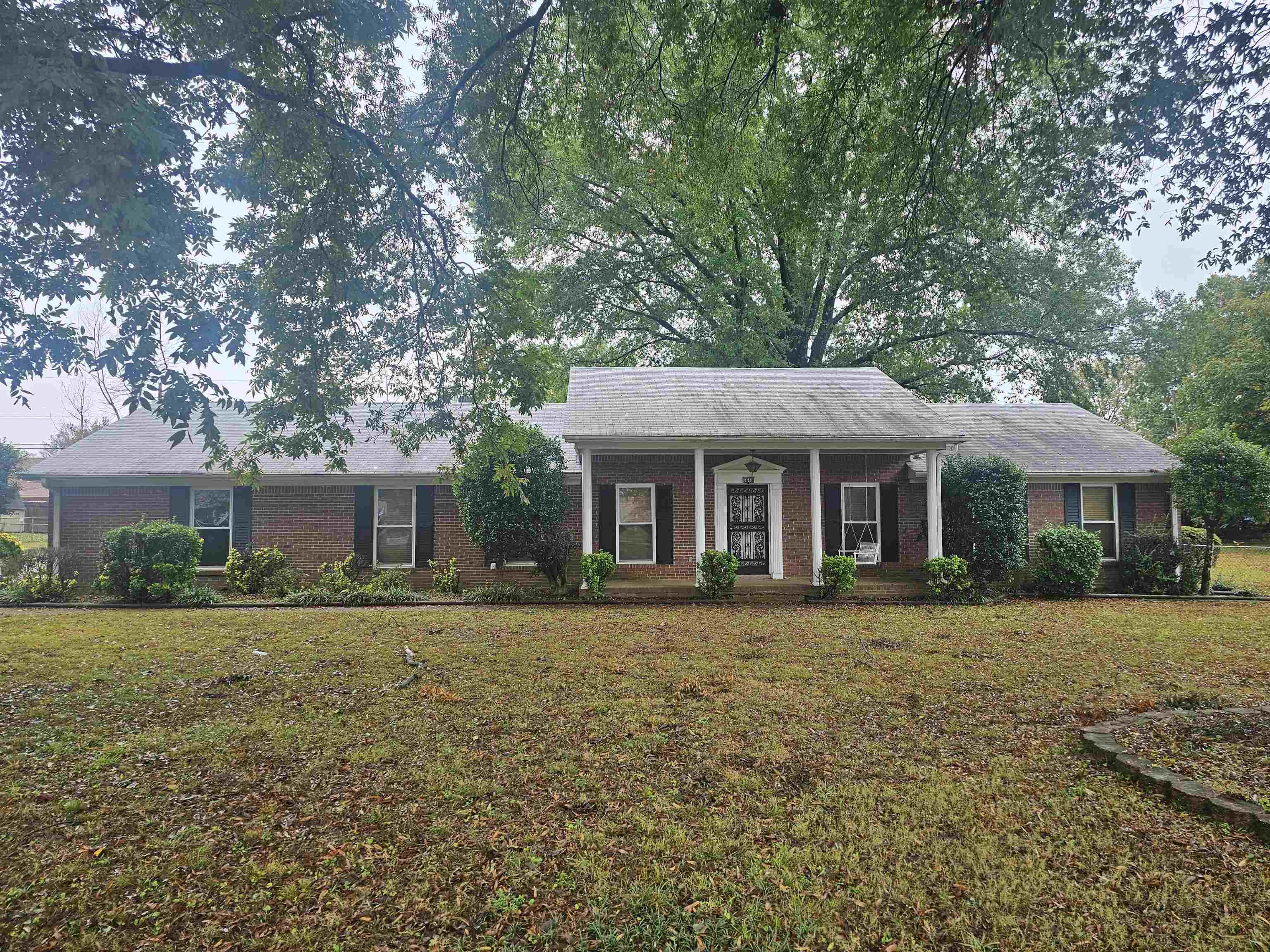 Ranch-style house featuring a porch and a front lawn