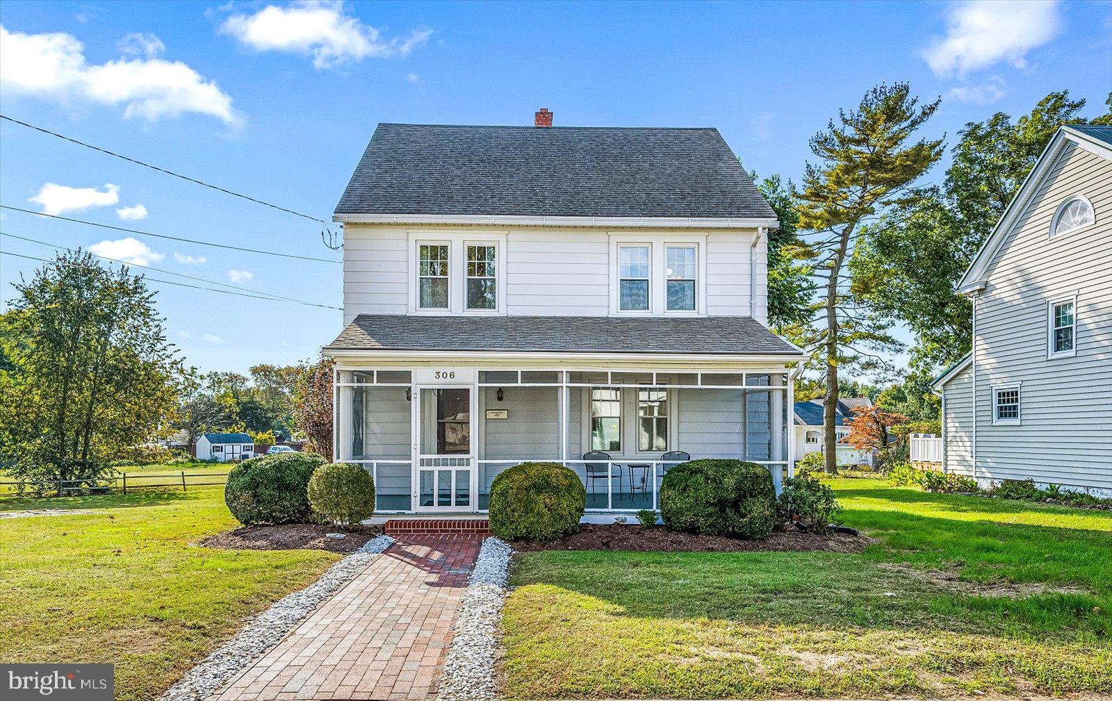 a front view of a house with a yard and potted plants