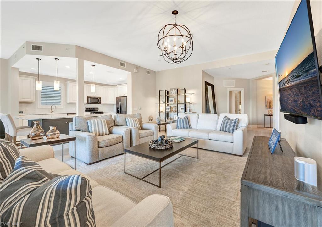 a living room with furniture kitchen view and a large window