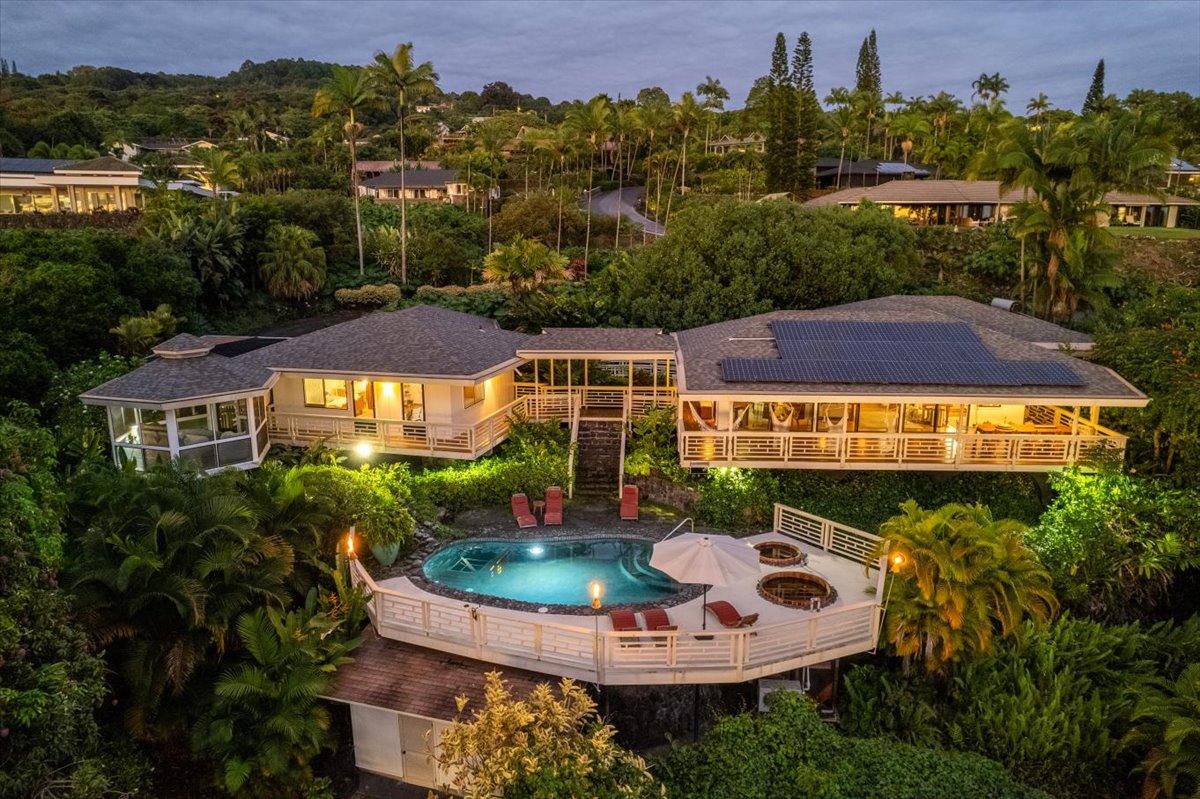 an aerial view of a house with a garden and lake view