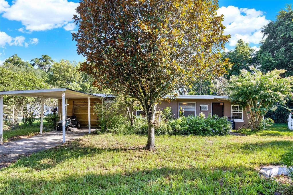 a view of a house with backyard and sitting area