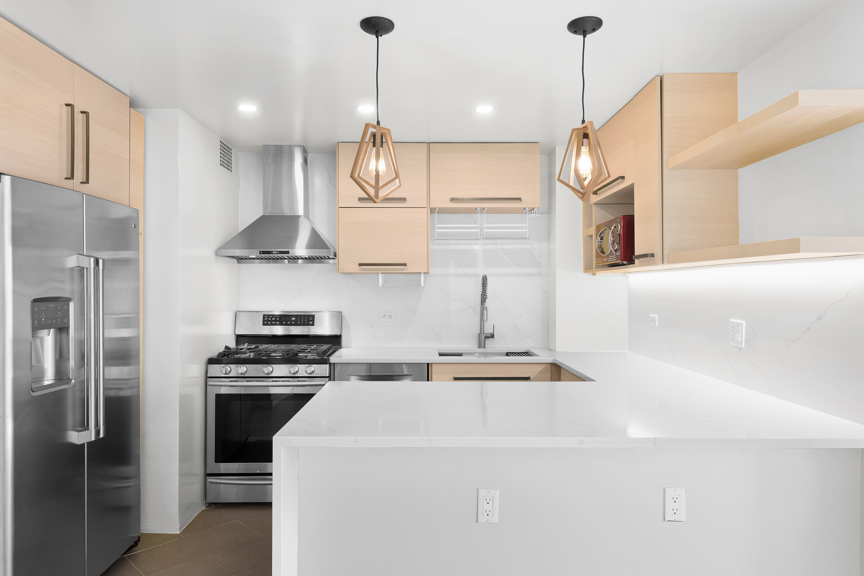 a kitchen with stainless steel appliances a stove a sink a refrigerator and cabinets