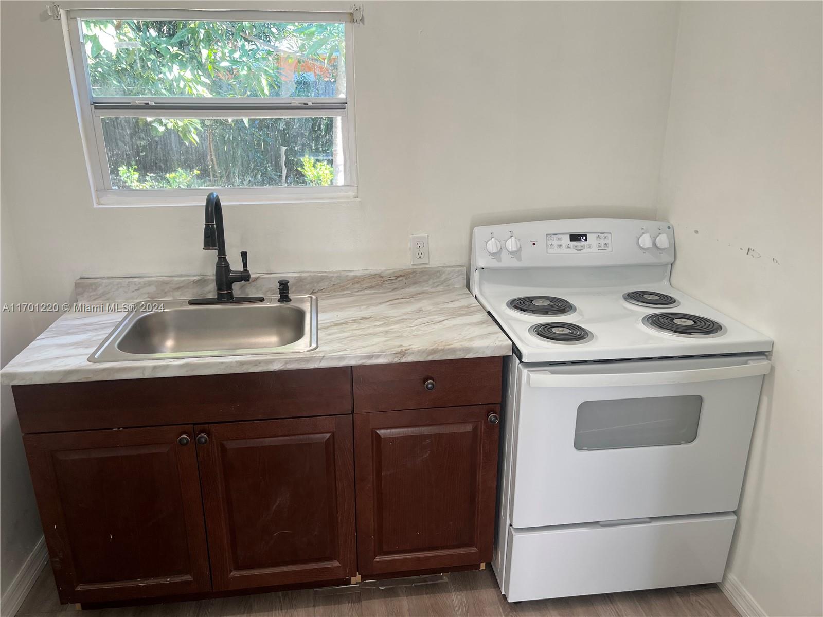 a kitchen with a stove cabinets and a sink