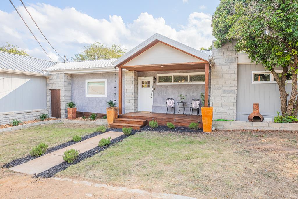 a view of a house with backyard and sitting area