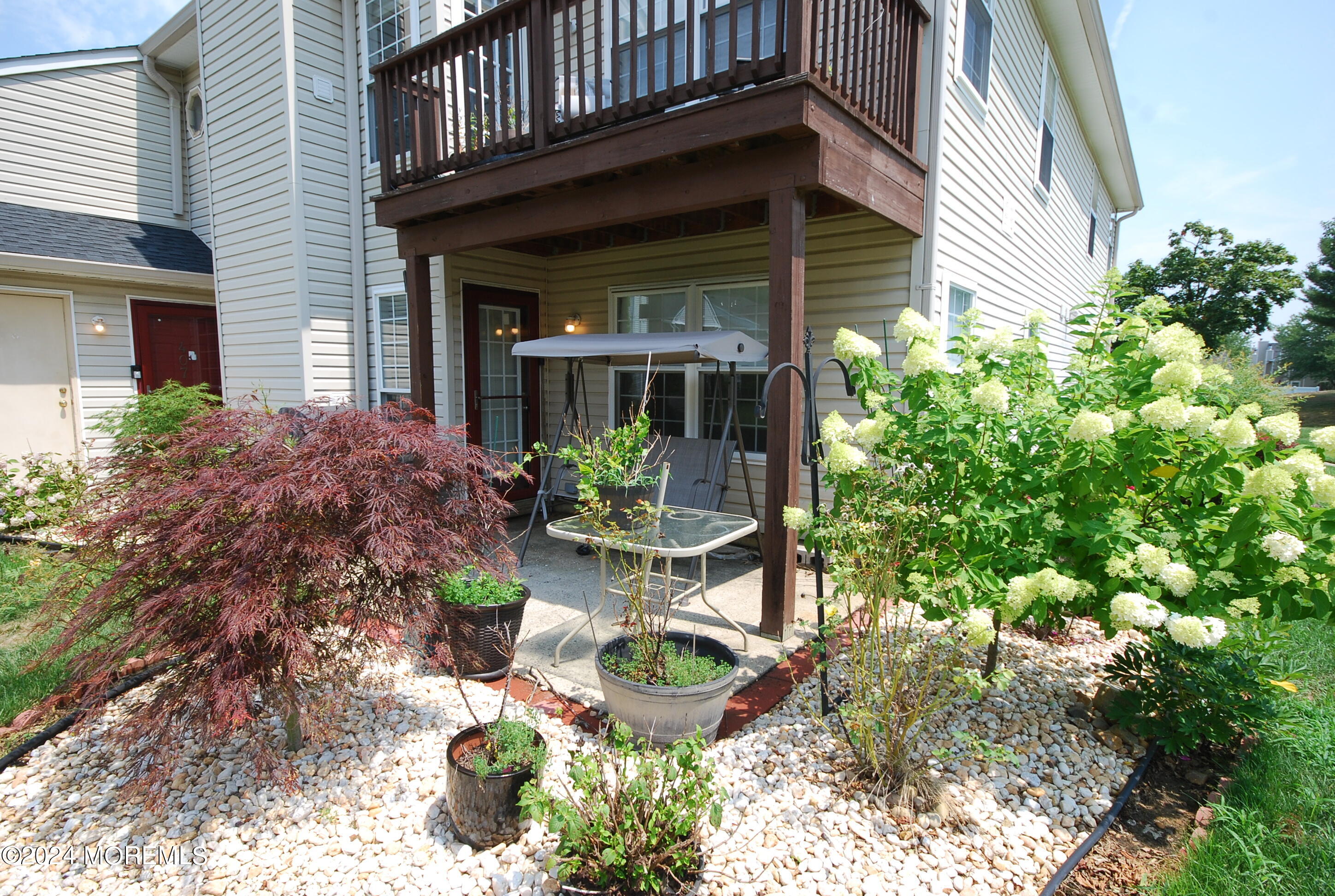 a front view of a house with garden and plants