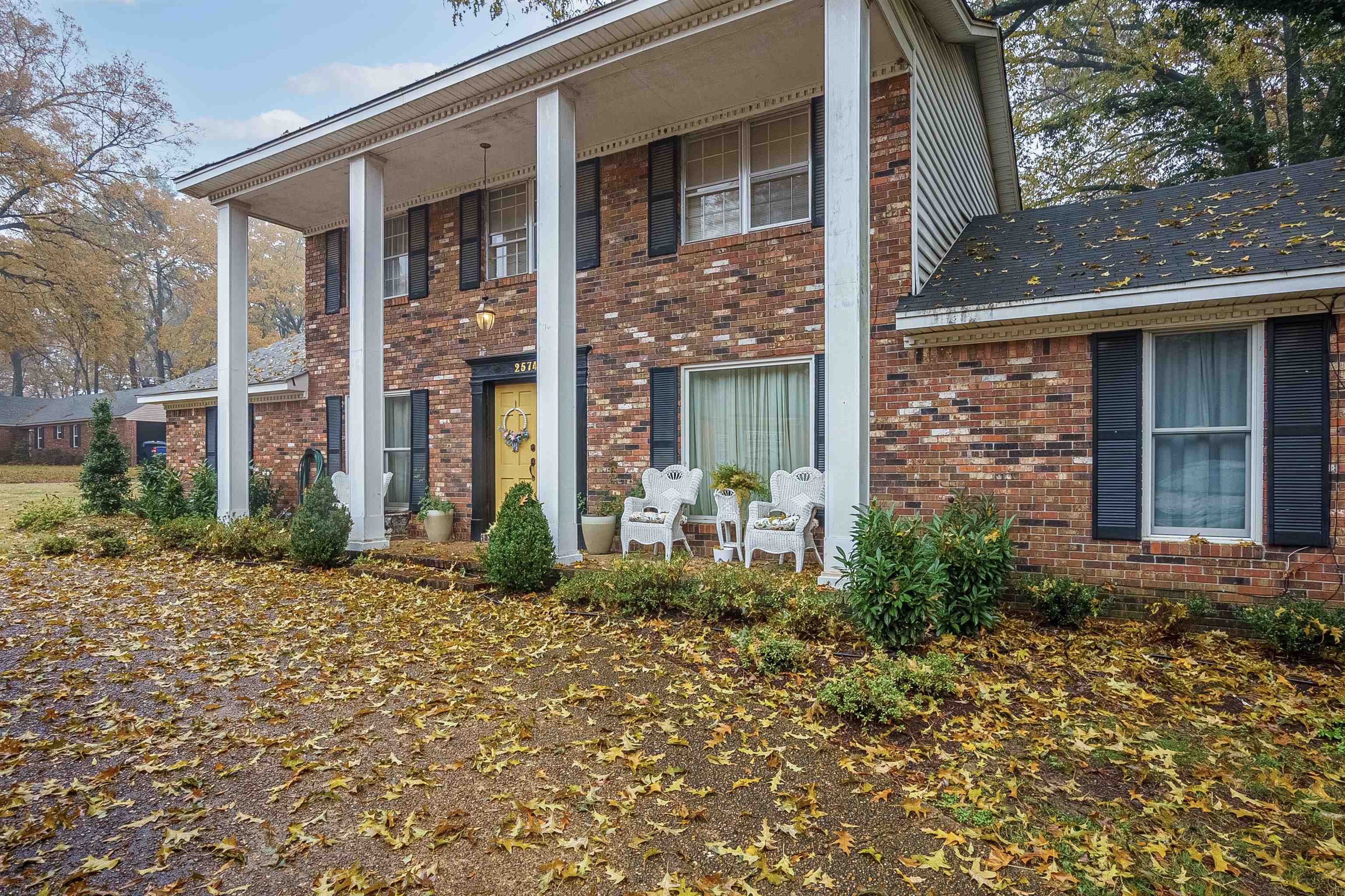 front view of a brick house with a small yard