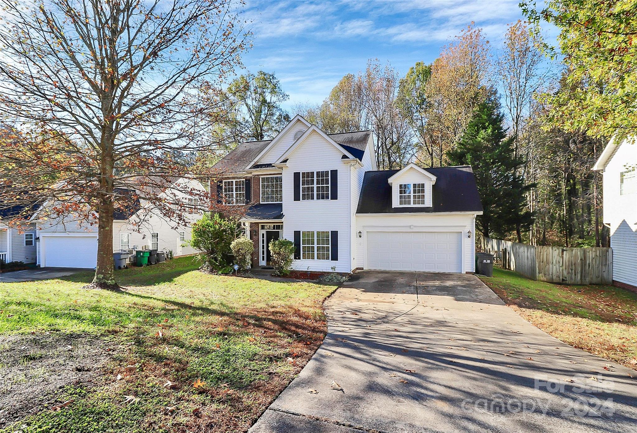 a front view of a house with a yard and trees