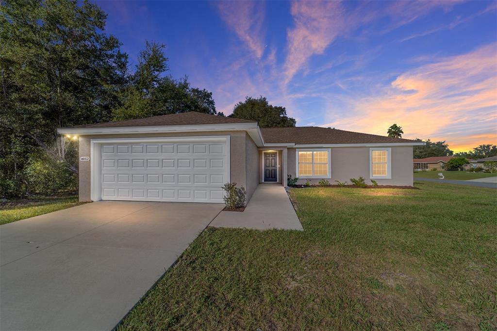 a front view of a house with a yard and garage