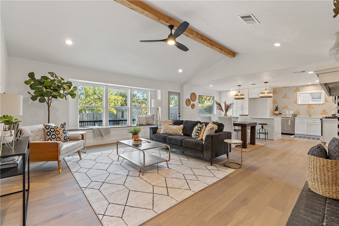 a living room with fireplace furniture and a large window