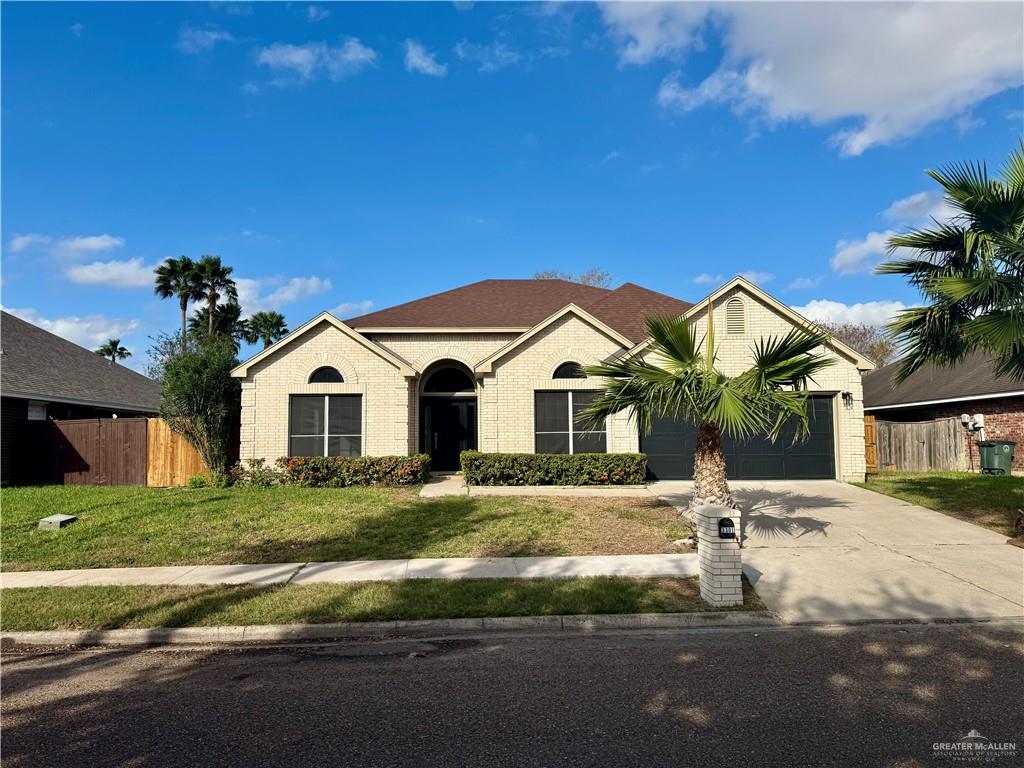 View of front of home with a front lawn and a garage