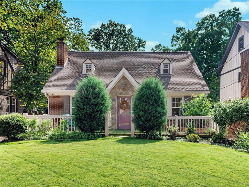 front view of house with a yard and potted plants