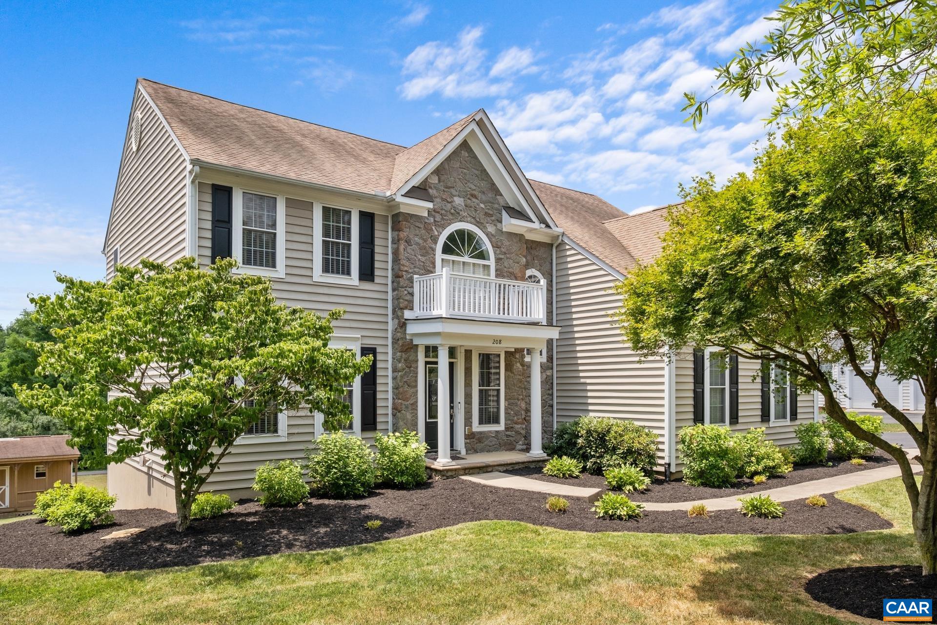 a front view of a house with yard and green space