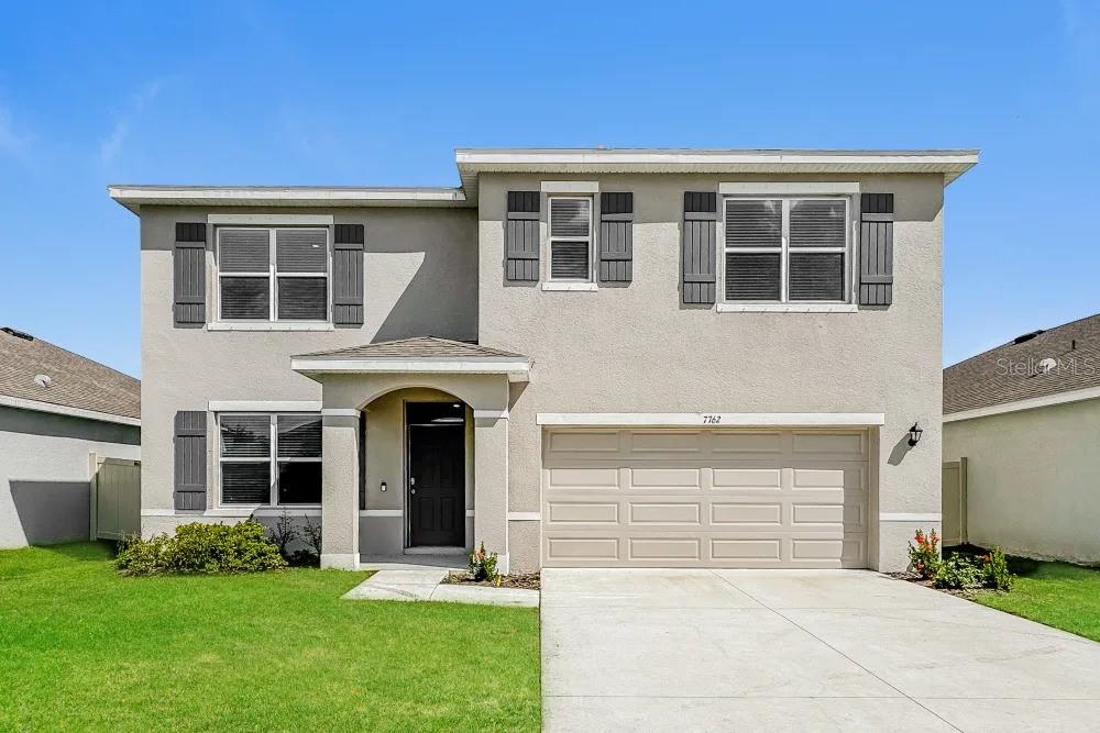 a front view of a house with a yard and garage