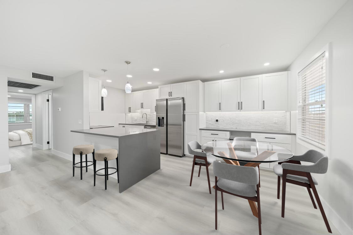 a kitchen with kitchen island wooden cabinets and refrigerator