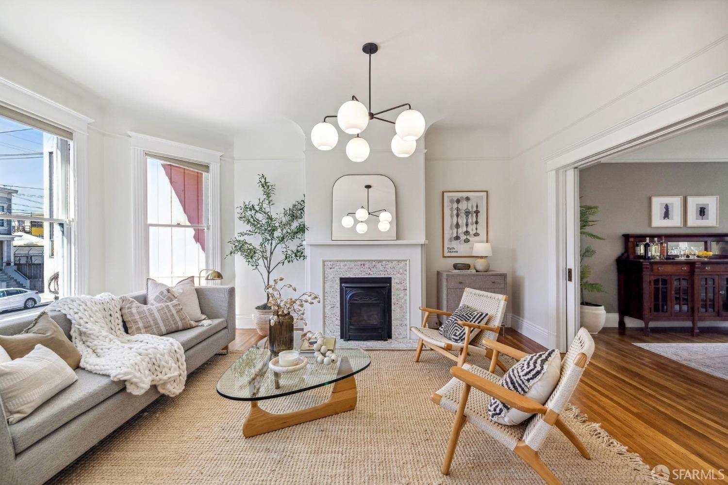 a living room with furniture a fireplace and a chandelier