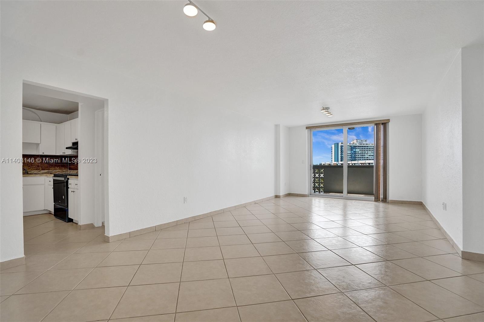 an empty room with kitchen and fireplace