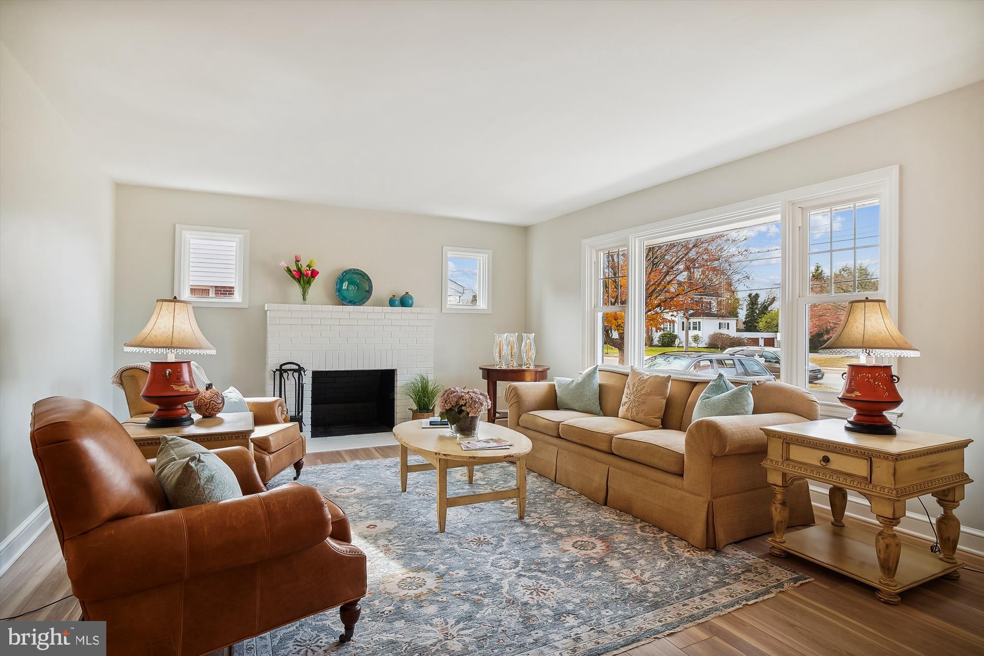 a living room with furniture a fireplace and a large window