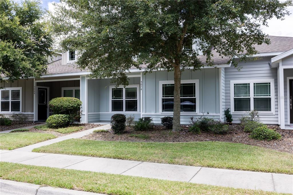 a front view of a house with garden and porch