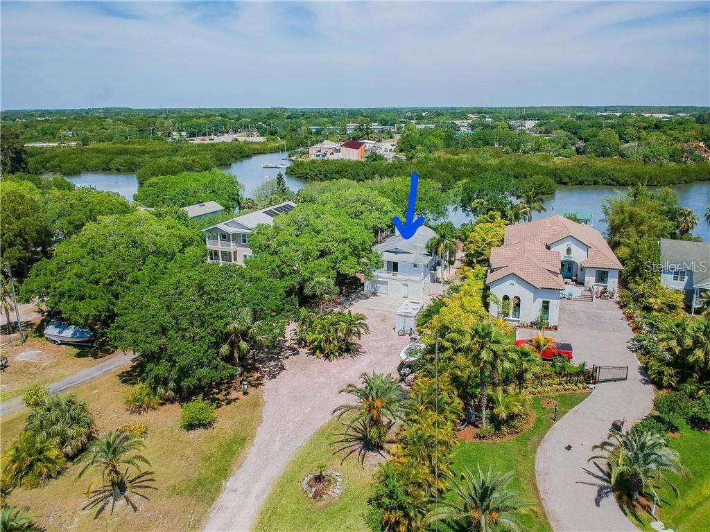 an aerial view of a houses with outdoor space and trees all around