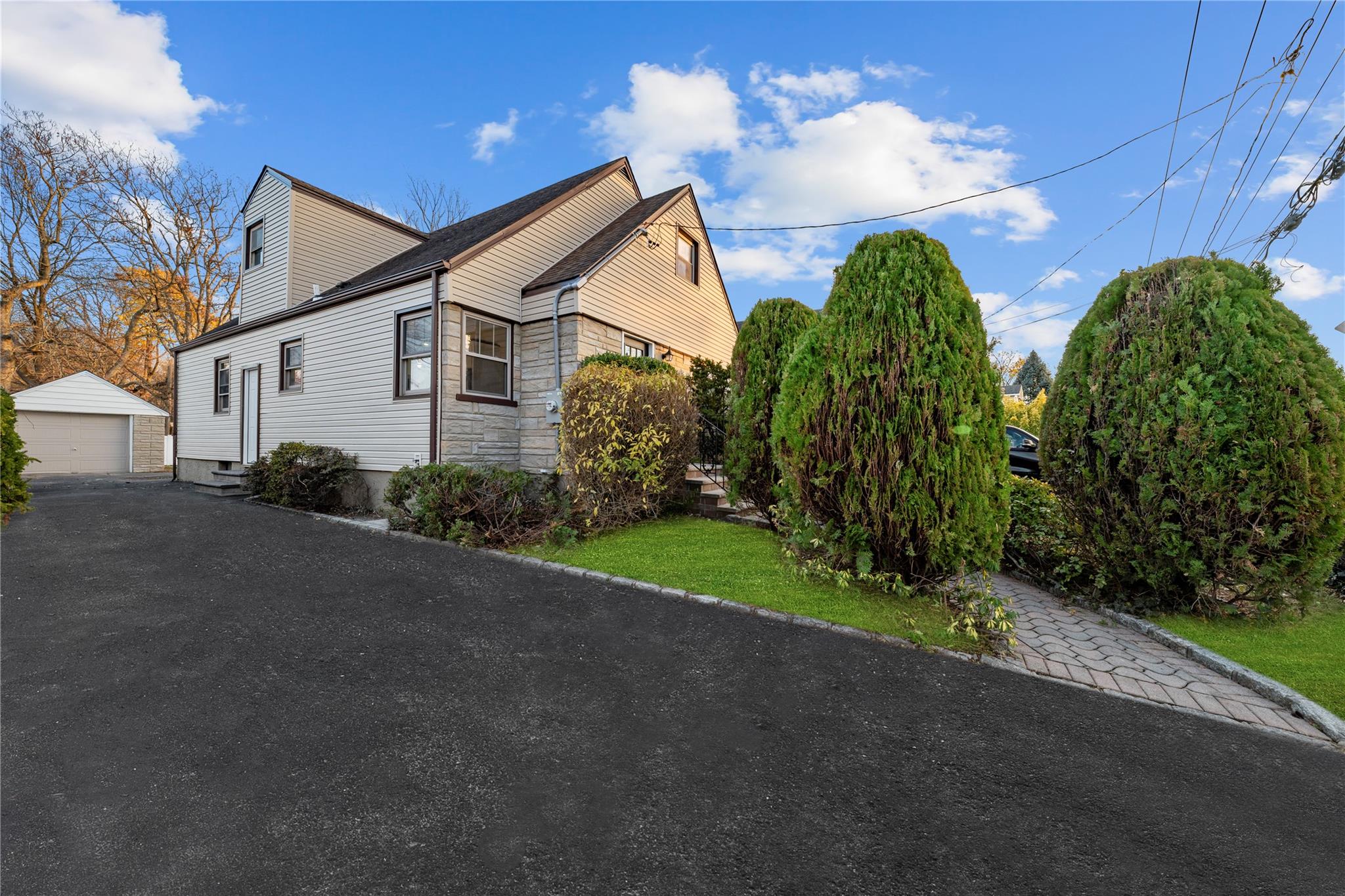 View of property exterior featuring an outbuilding and a garage