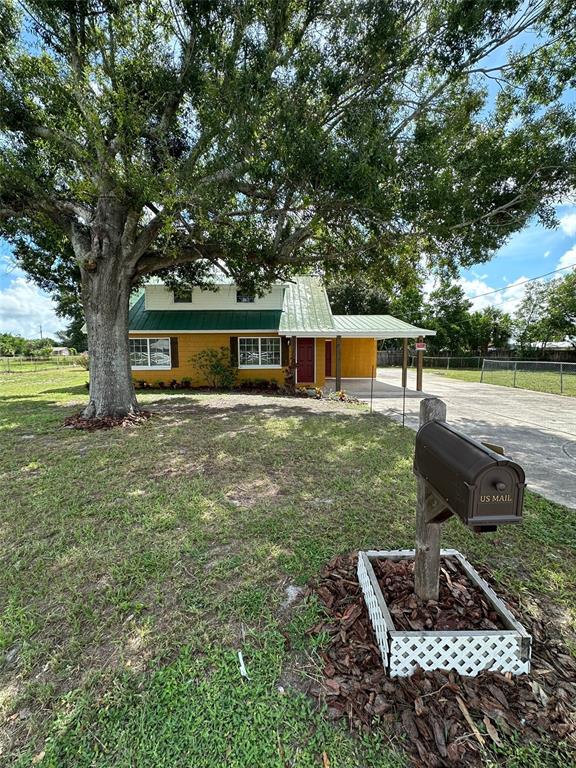 a view of a house with backyard and a tree