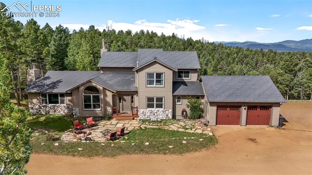 View of front of home with a mountain view and a garage