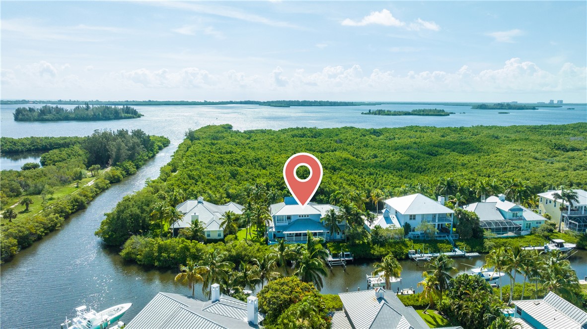 a aerial view of a house with a yard and lake view