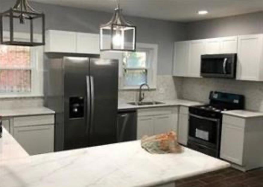 a kitchen with granite countertop a refrigerator stove and sink