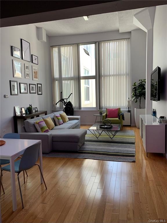 a living room with furniture wooden floor and a large window