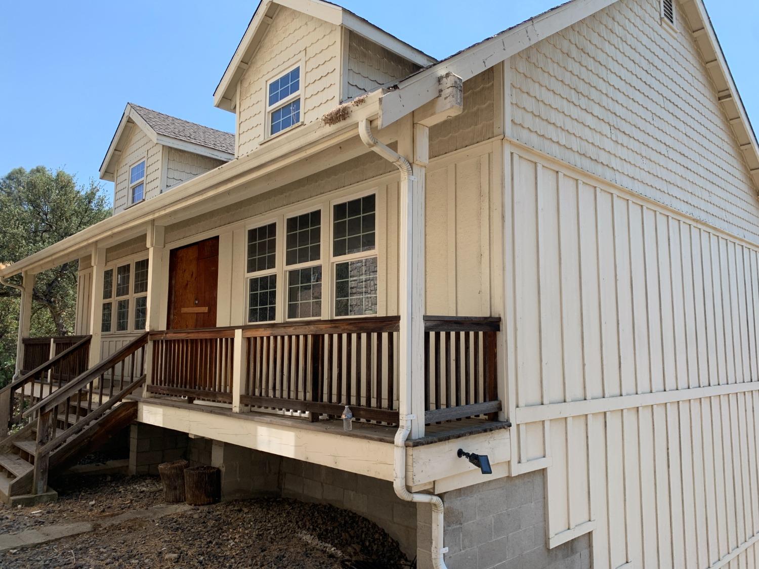 a view of a house with wooden deck and a chair