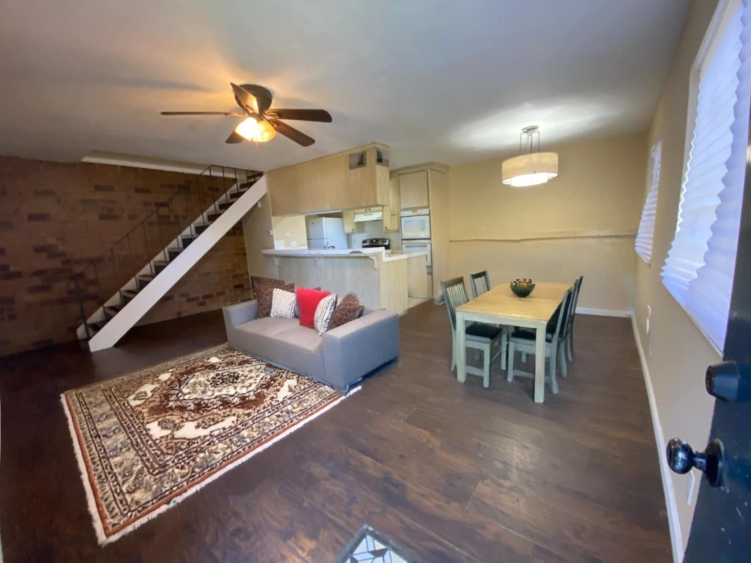 a living room with furniture and a wooden floor