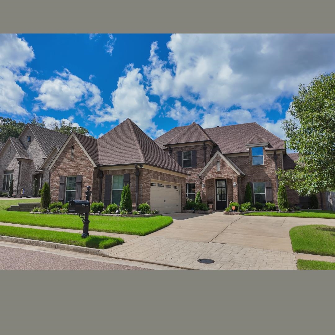 a front view of a house with a yard and trees