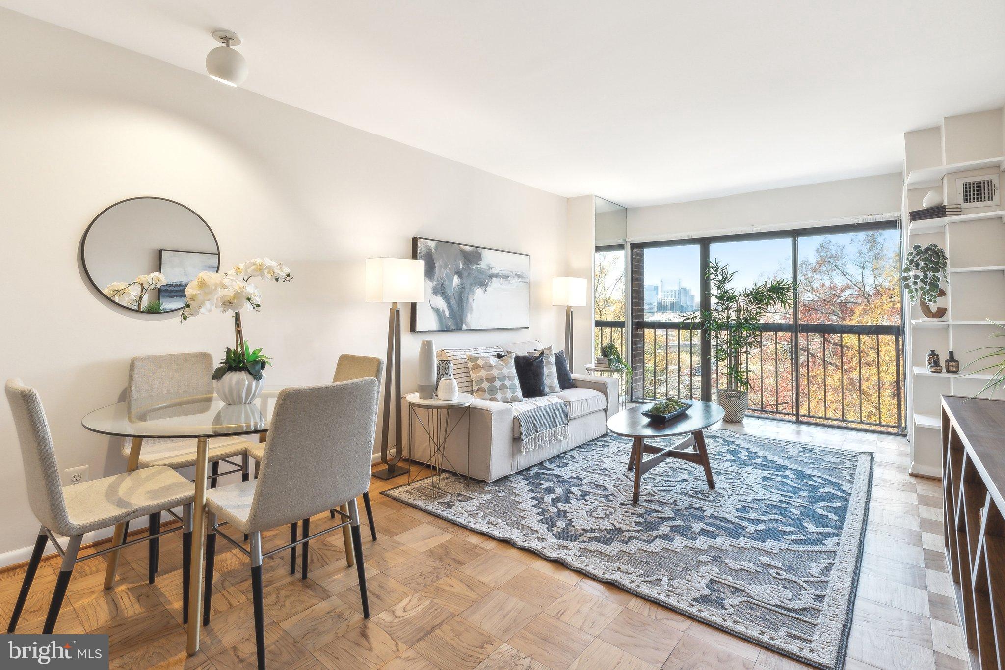 a living room with furniture a fireplace and a floor to ceiling window