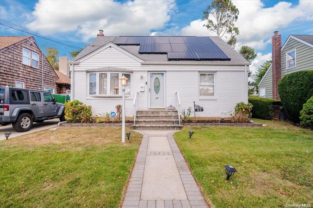 a front view of a house with a garden and plants