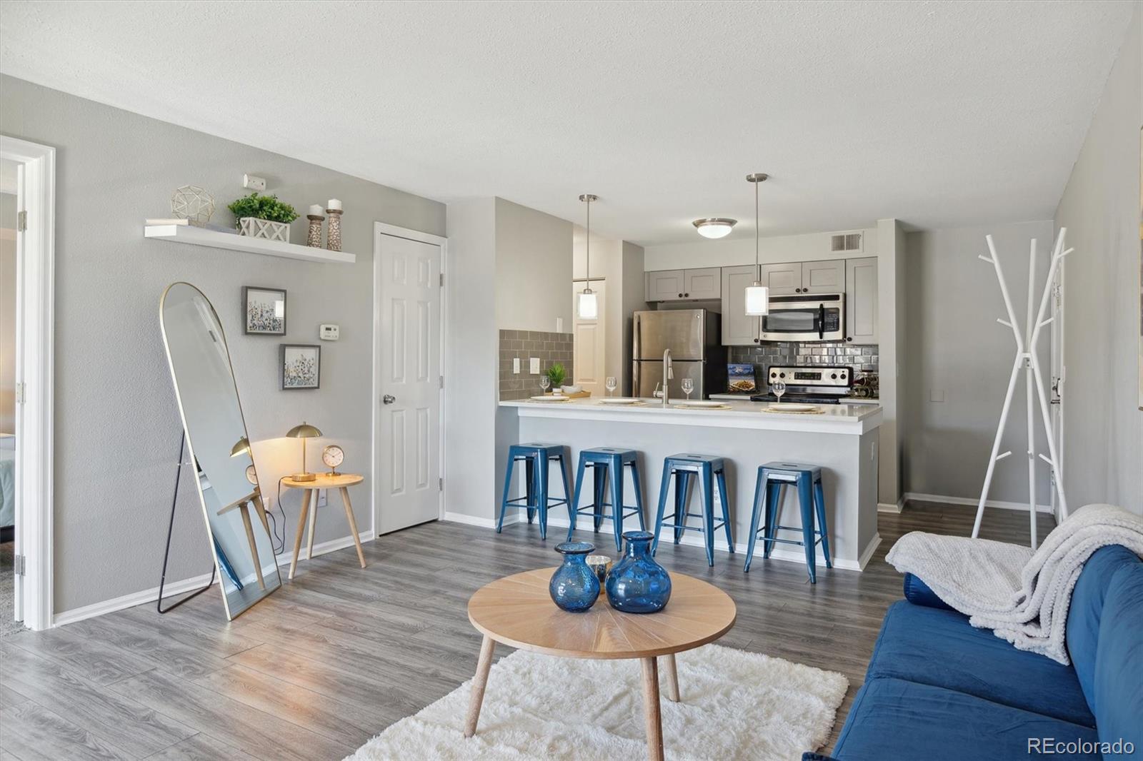 a dining room with furniture a kitchen view and wooden floor