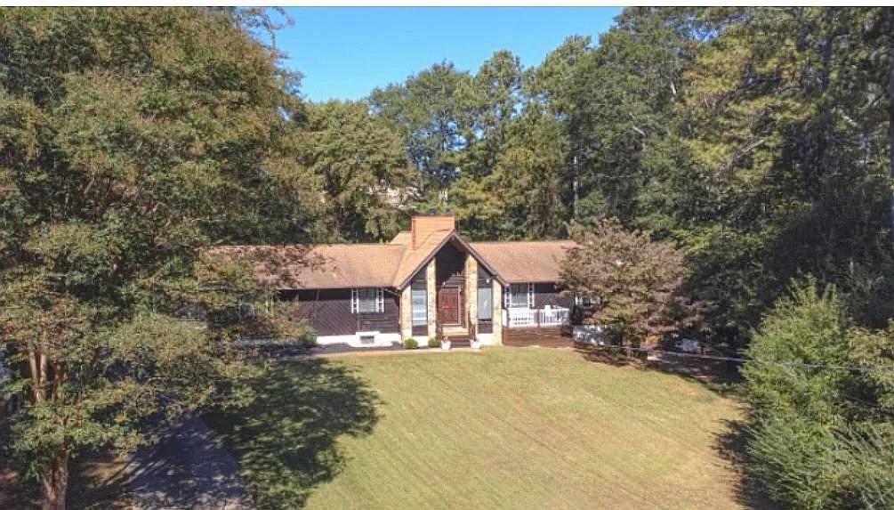 a view of house with outdoor space and trees around