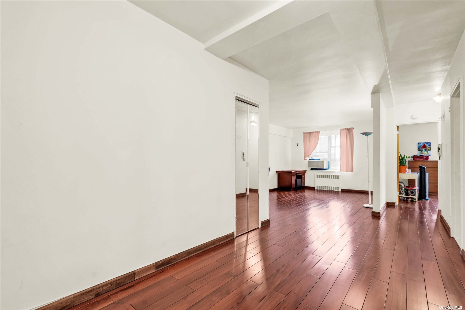 a view of empty room with wooden floor