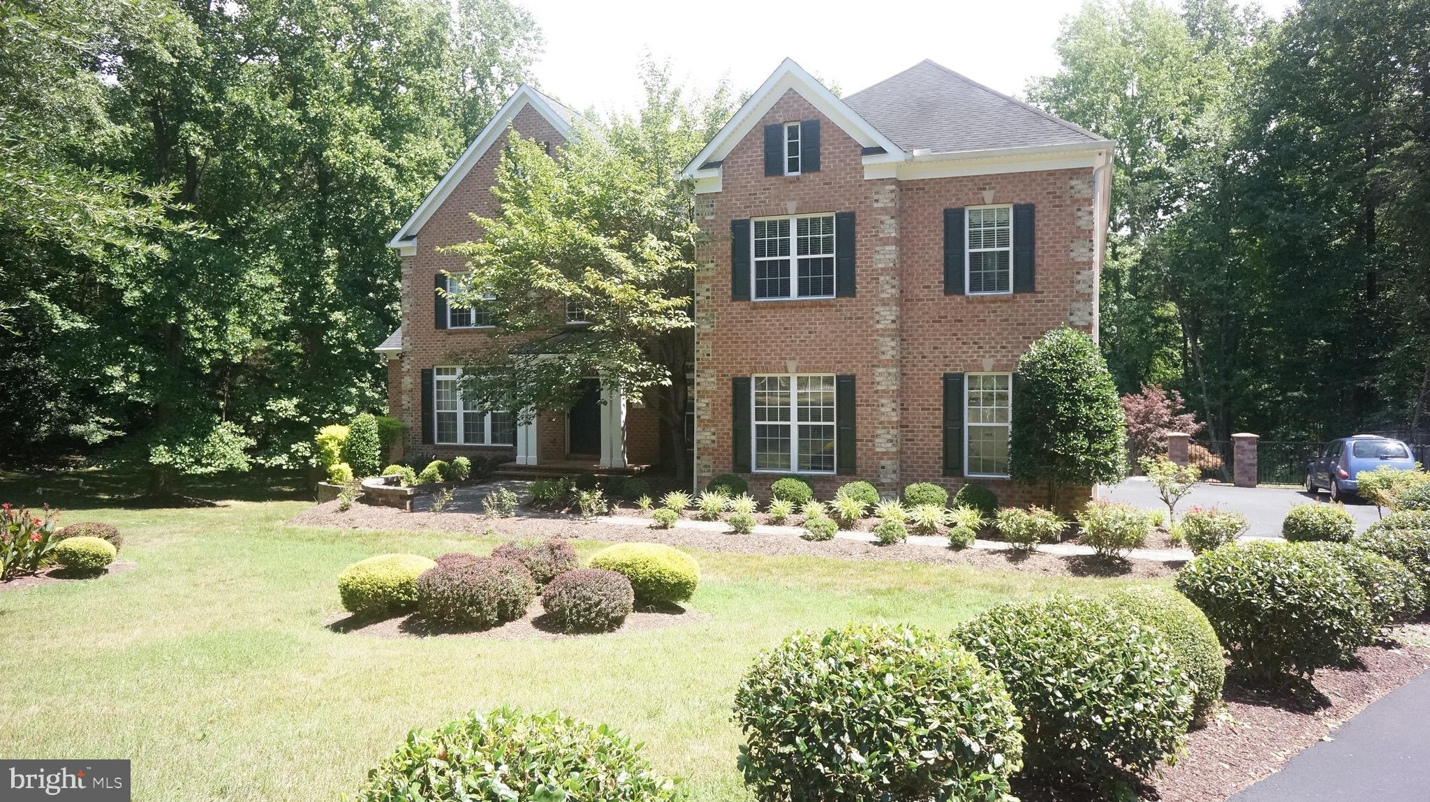 a front view of a house with a yard and trees