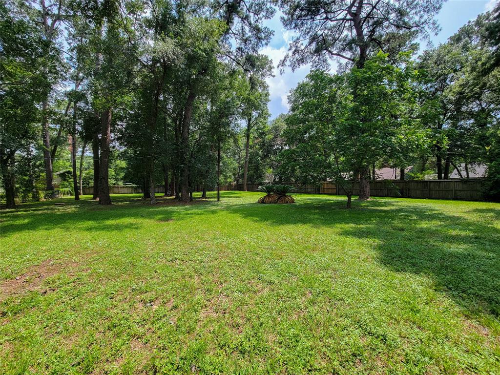 a view of grassy field with benches and trees all around