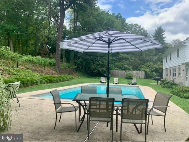 a view of patio with chairs and table under an umbrella