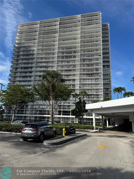 a front view of a building with cars parked