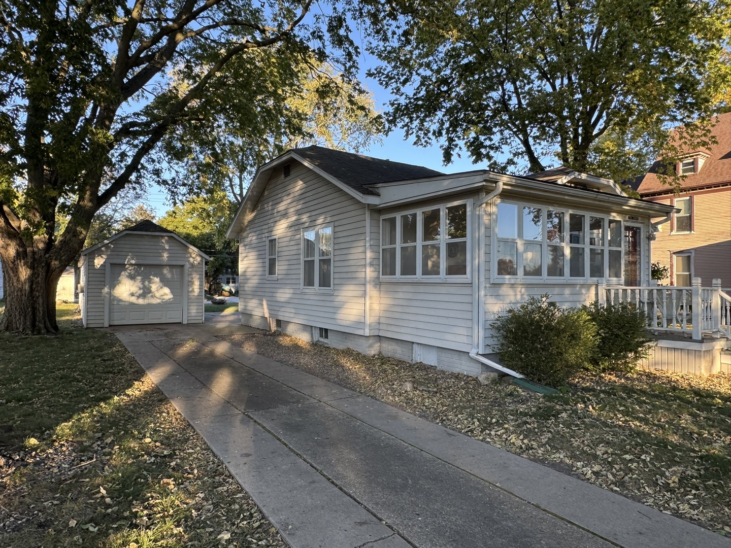 a front view of a house with a garden and trees