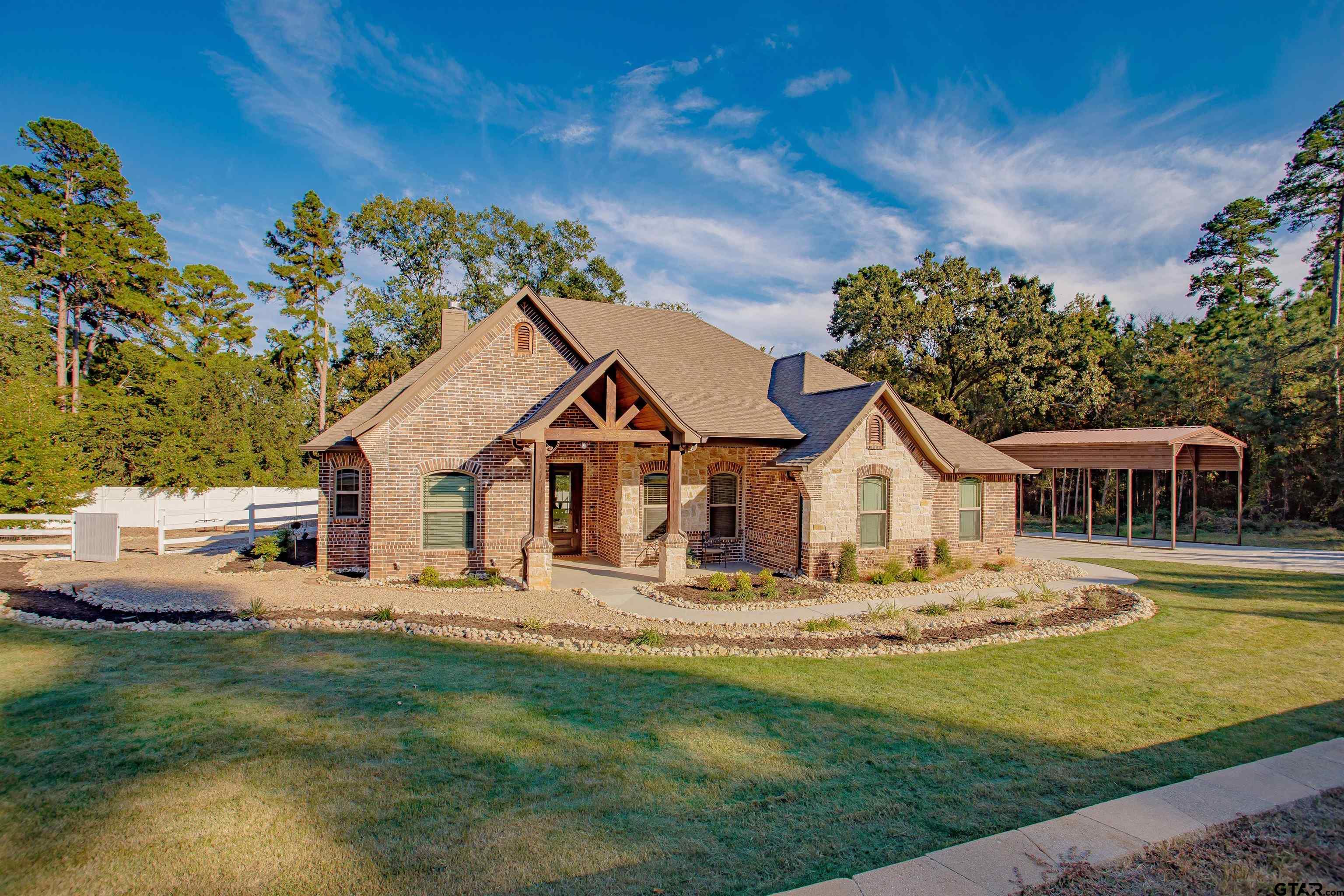 a front view of a house with a garden and plants