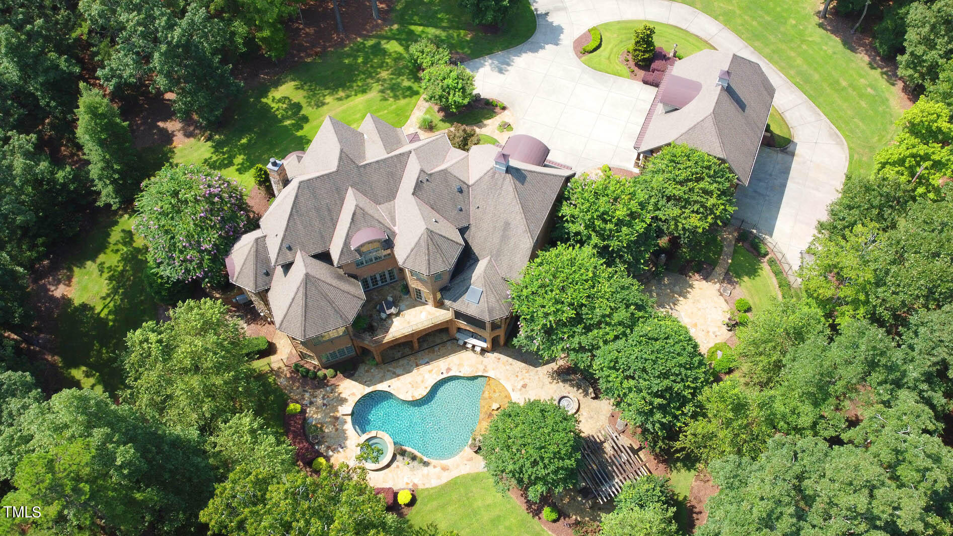 an aerial view of a house with a yard and a large tree