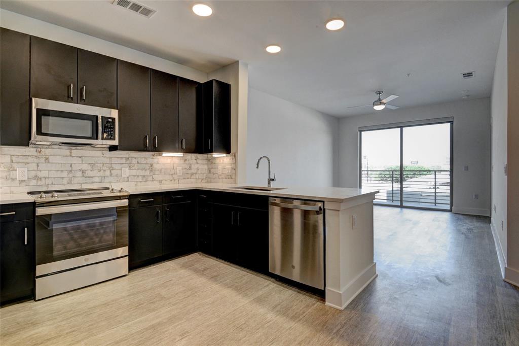 a kitchen with stainless steel appliances granite countertop a stove a sink and a microwave