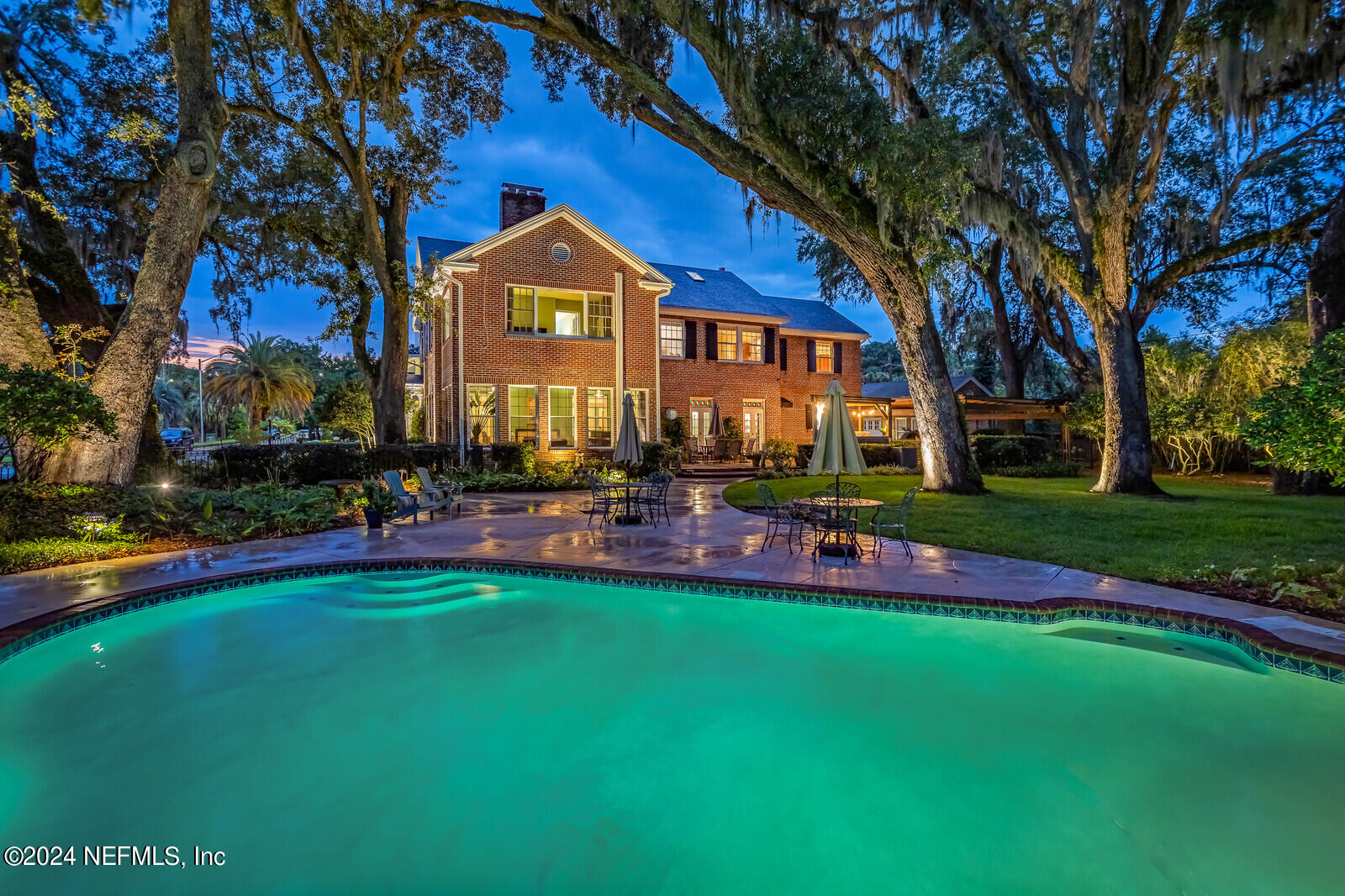 a front view of a house with swimming pool and chairs