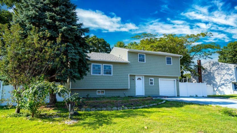 View of front of house featuring a front yard and a garage