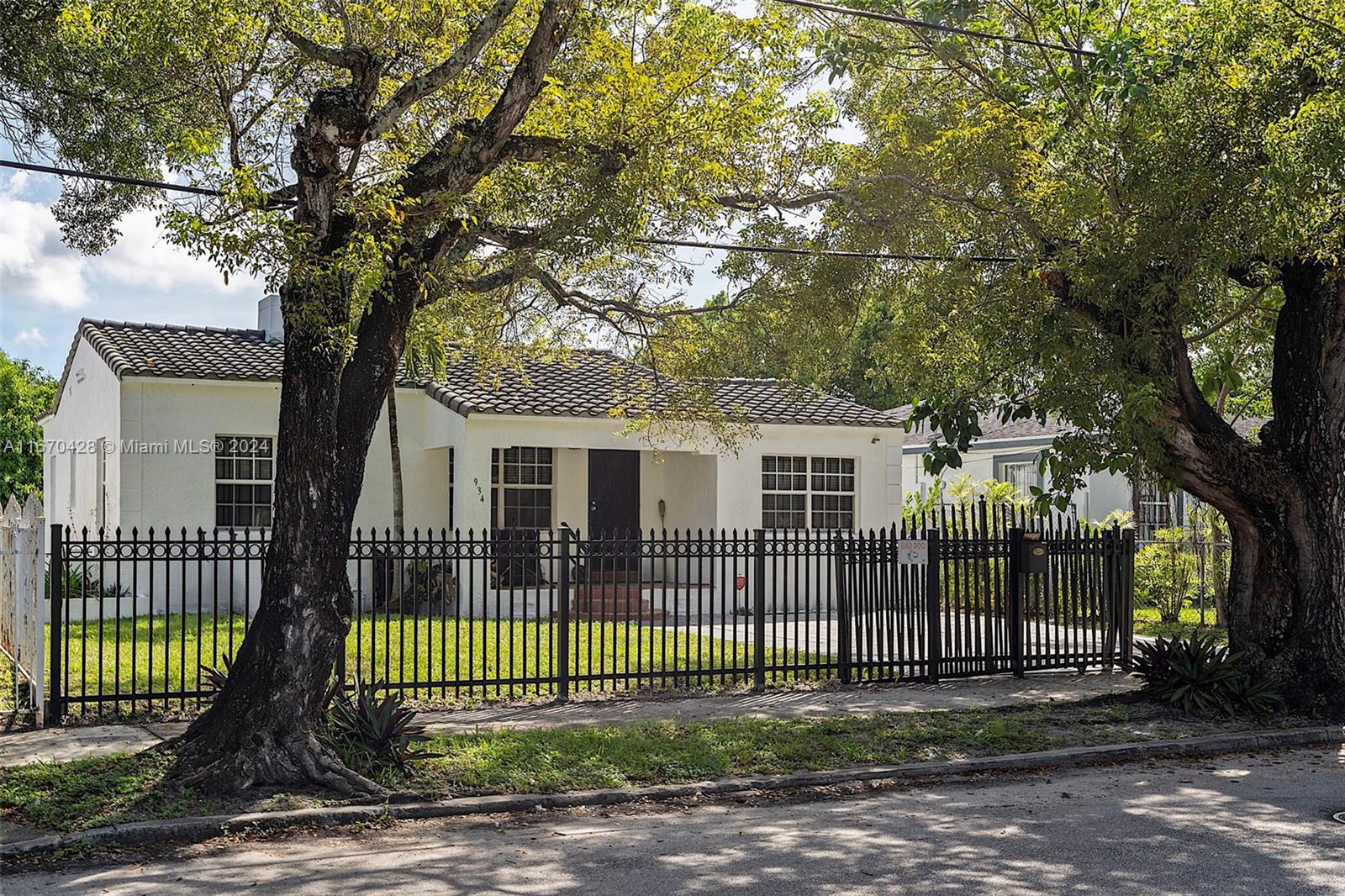 a front view of a house with a garden and trees